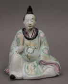 A Chinese porcelain seated figure. 17 cm high.