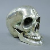 A silvered metal model of a skull. 9 cm high.