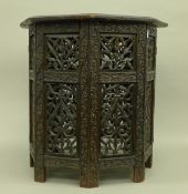 An Eastern carved folding table and a jardinere stand. The former 45.5 cm wide.