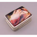 A silver pill box depicting a reclining lady. 3 cm x 2.5 cm.