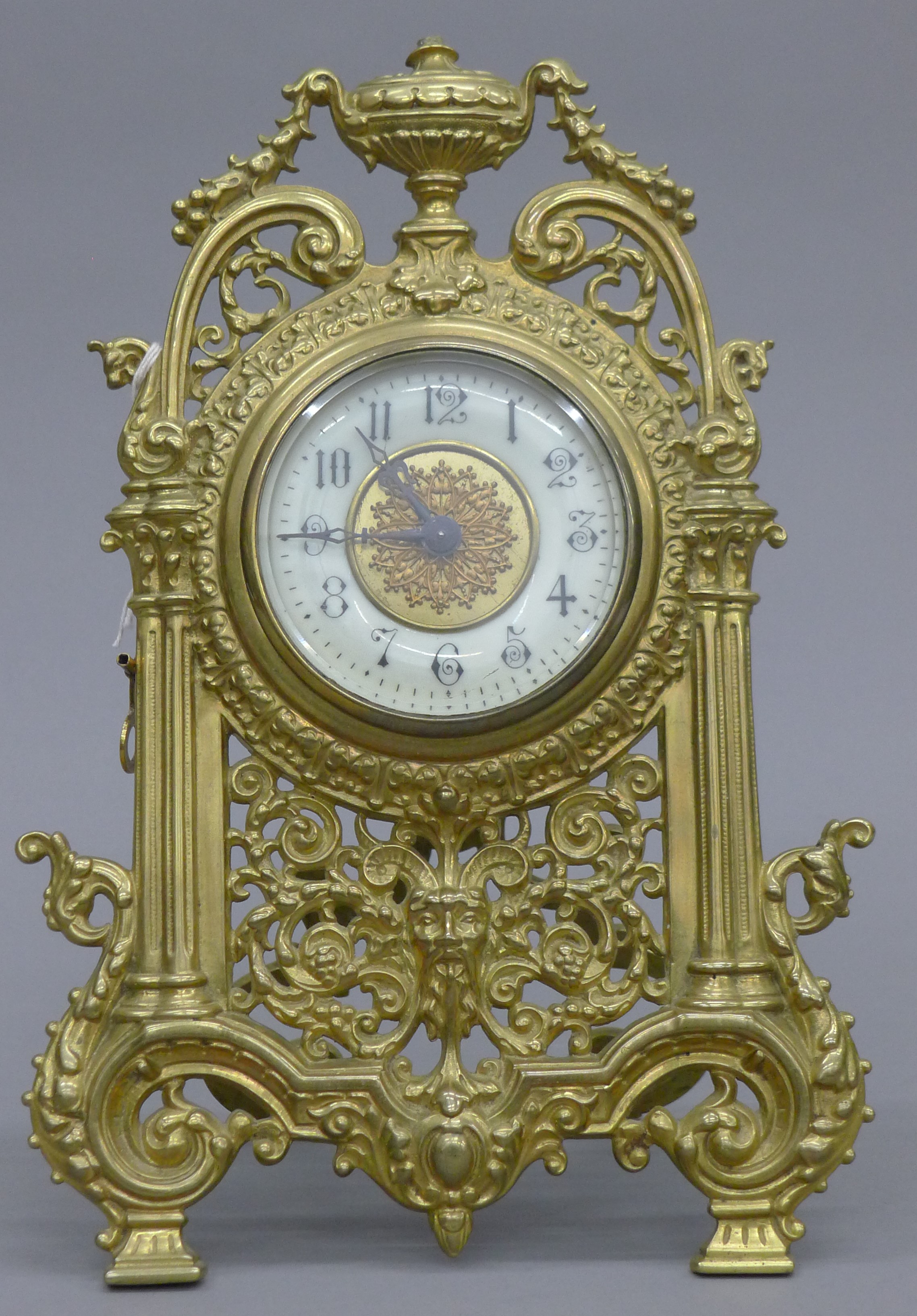 A brass strutt clock. 32 cm high.