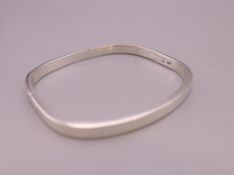 A silver bangle bracelet. 6 cm internal diameter.