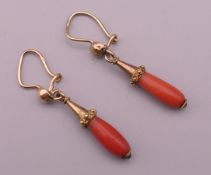 A pair of gold coral drop earrings. 2 cm high excluding suspension hook.