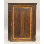 A George III oak and mahogany corner cupboard. 85 cm wide.
