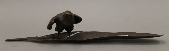 An antique Vienna cold painted bronze eagle standing on a large feather,