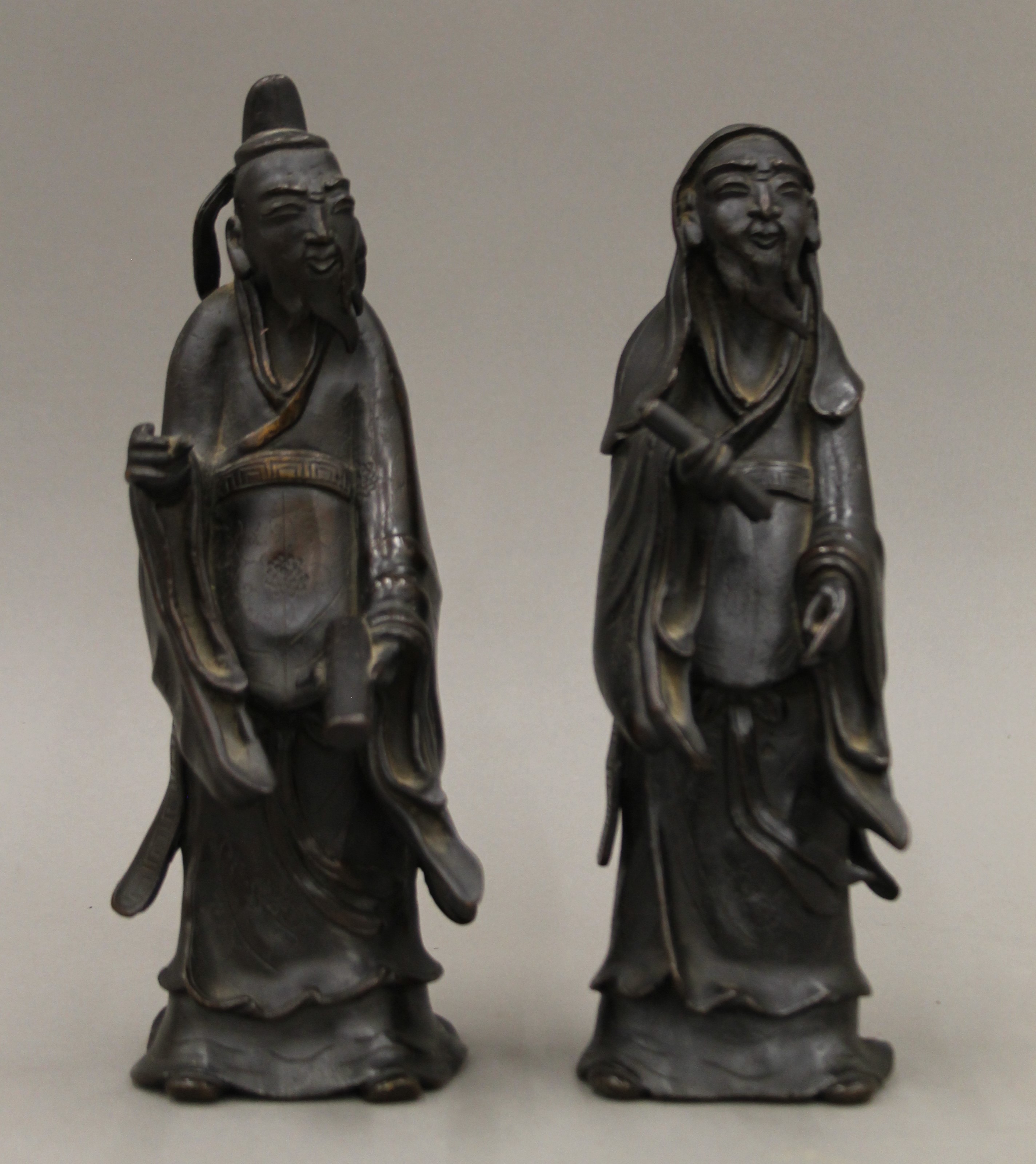 A pair of Chinese bronze models of sages. The largest 25 cm high.