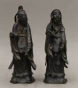 A pair of Chinese bronze models of sages. The largest 25 cm high.