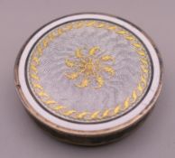 An unmarked enamel decorated cigar cutter/box. 3 cm diameter.