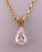 An 18 K gold chain with stone set drop pendant. Pendant 1 cm high, chain approximately 45 cm long.