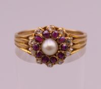 A gold, probably 18 ct gold, pearl, ruby and diamond ring. Ring size O. 3.1 grammes total weight.