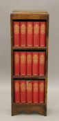 A small early 20th century oak bookcase containing Dickens books. 30 cm wide.