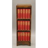 A small early 20th century oak bookcase containing Dickens books. 30 cm wide.