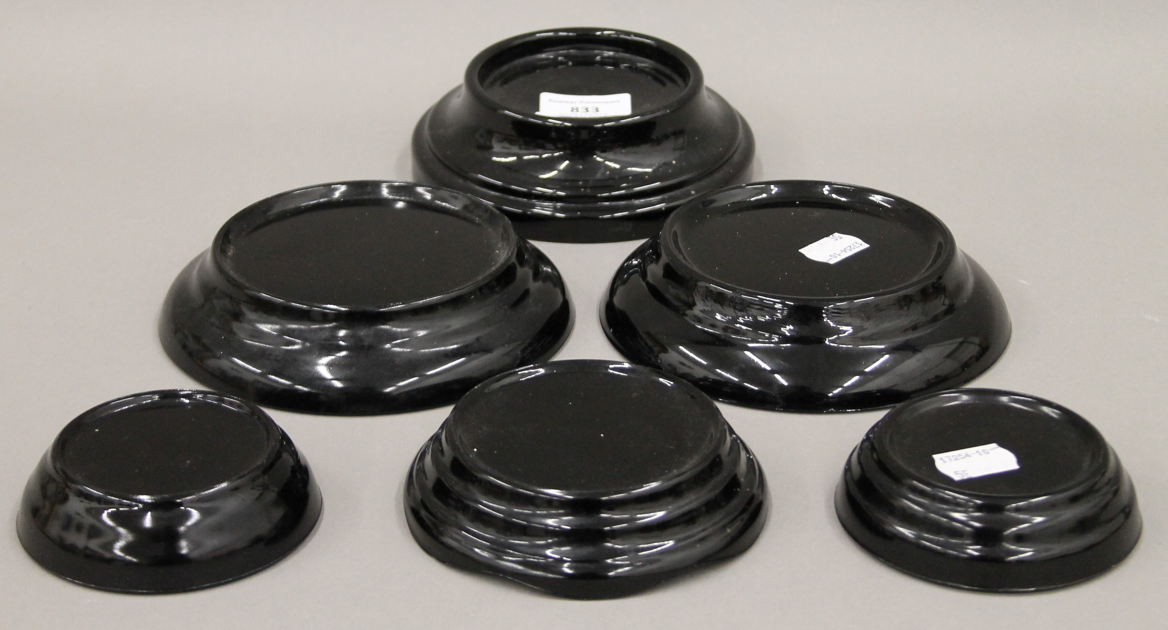 Six vintage black glass stands. The largest 15 cm diameter.