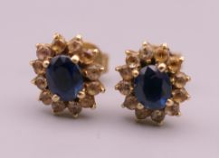 A pair of gold sapphire and diamond earrings. 1 cm high.
