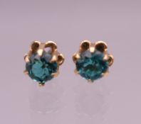 A pair of 9 ct gold earrings set with blue stones, possibly blue zircons, boxed. 0.5 cm diameter.