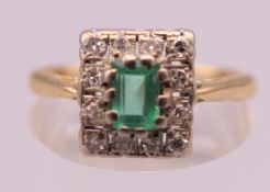 An 18 ct gold emerald and diamond ring. Ring size Q. 3.7 grammes total weight.