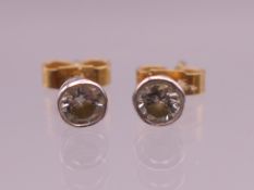A pair of gold and diamond stud earrings, each spreading to approximately .25 carat. 0.