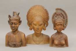 Three Eastern carved wooden busts. The largest 26 cm high.