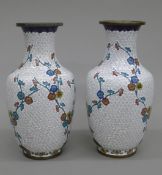 A pair of 19th century Chinese white ground cloisonne vases decorated with sprigs of flowers.