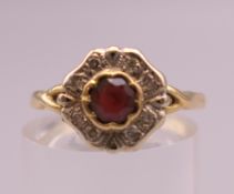 An 18 ct gold diamond and ruby flowerhead ring. Ring size O. 3 grammes total weight.