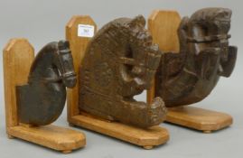 Three carved wooden horses heads, on later mounts. The largest 21.5 cm high.