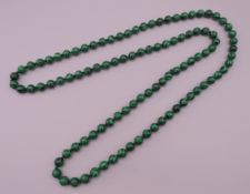 A malachite bead necklace. Approximately 92 cm long.