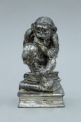 After GERTRUDE A MEREDITH, a silvered pewter sculpture of an ape perusing a human skull,