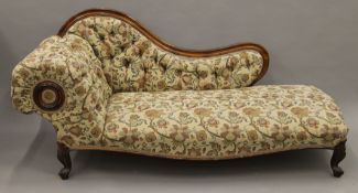 A Victorian upholstered walnut chaise lounge. Approximately 180 cm long.