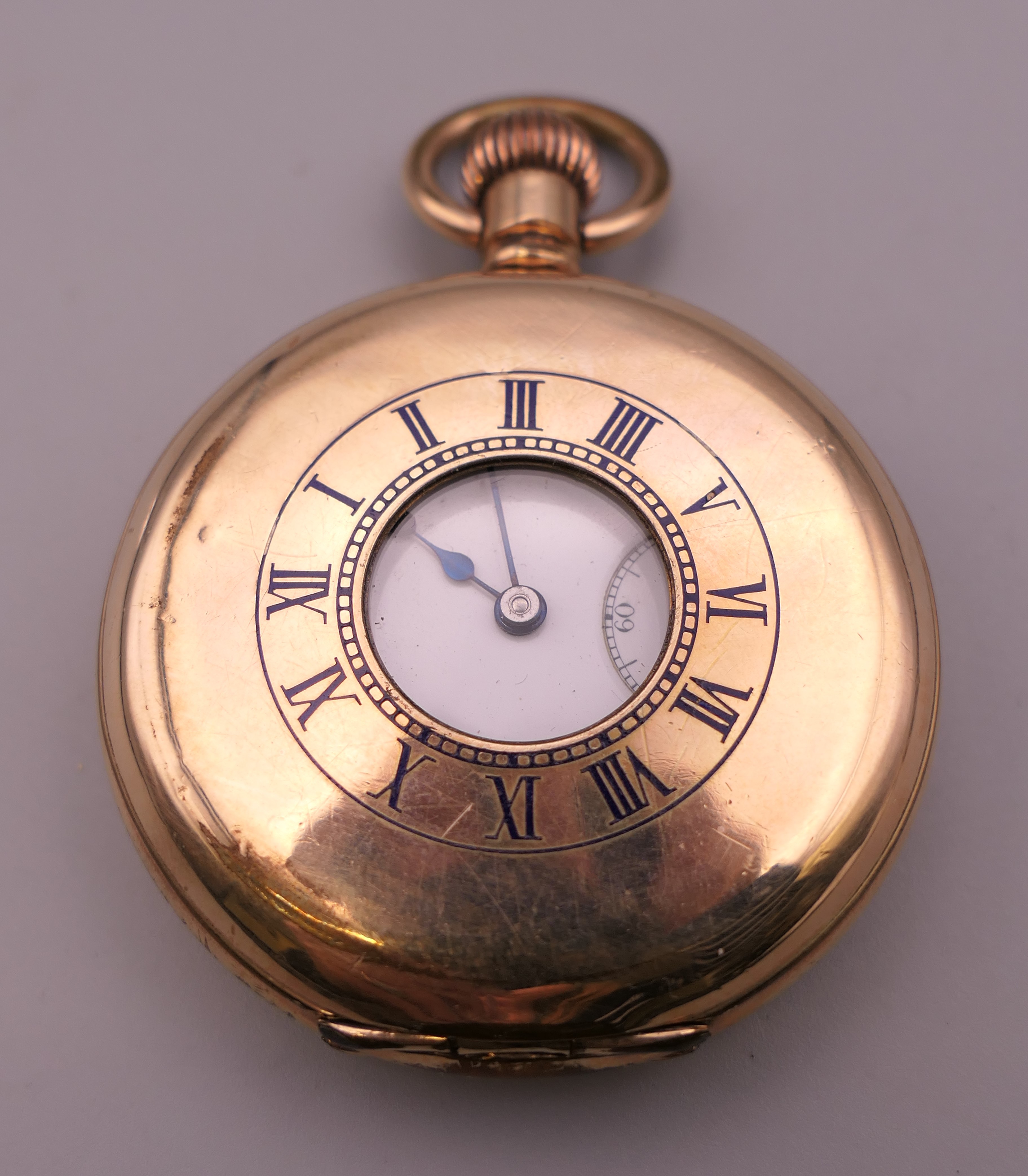 A gold plated half hunter pocket watch. 5 cm diameter.