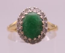 An 18 ct gold emerald and diamond ring. Ring size P/Q. 4.7 grammes total weight.