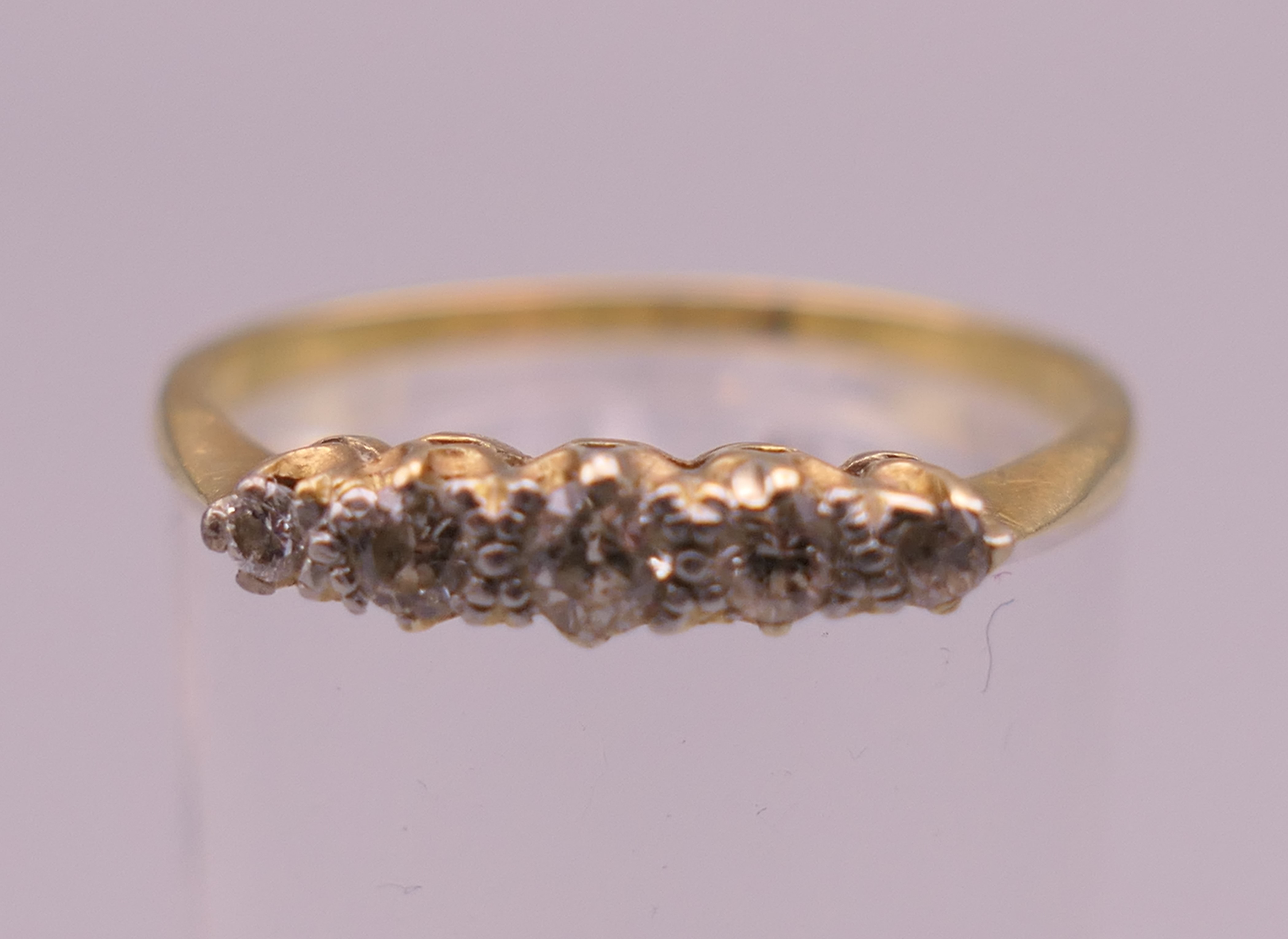 An 18 ct gold five stone diamond ring. Ring P/Q. 1.9 grammes total weight.