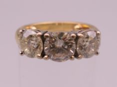 An 18 ct gold three stone diamond ring;