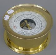 A brass barometer. 17.5 cm diameter.