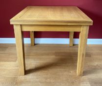 A modern oak extending flip-top dining table. 90 cm square when closed.