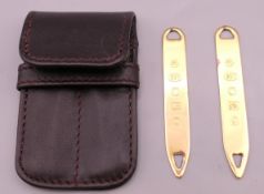 A pair of silver gilt collar straighteners in leather pouch. Each 6.25 cm long.