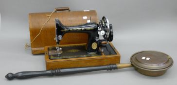 A Singer sewing machine and a copper warming pan.