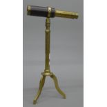 A small leather mounted brass telescope on stand.