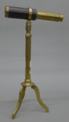 A small leather mounted brass telescope on stand.