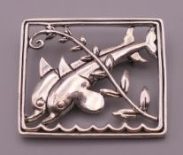 A silver brooch formed as two dolphins. 3.5 cm x 3 cm.