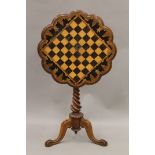 A Victorian inlaid tilt top tripod chess table. 58.5 cm diameter.