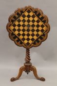 A Victorian inlaid tilt top tripod chess table. 58.5 cm diameter.