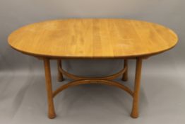 A blonde Ercol extending dining table and a set of four blonde Ercol dining chairs.