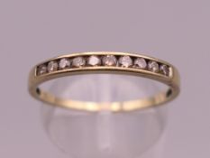 An unmarked 9 ct gold ten stone ring. Ring size S. 1.2 grammes total weight.