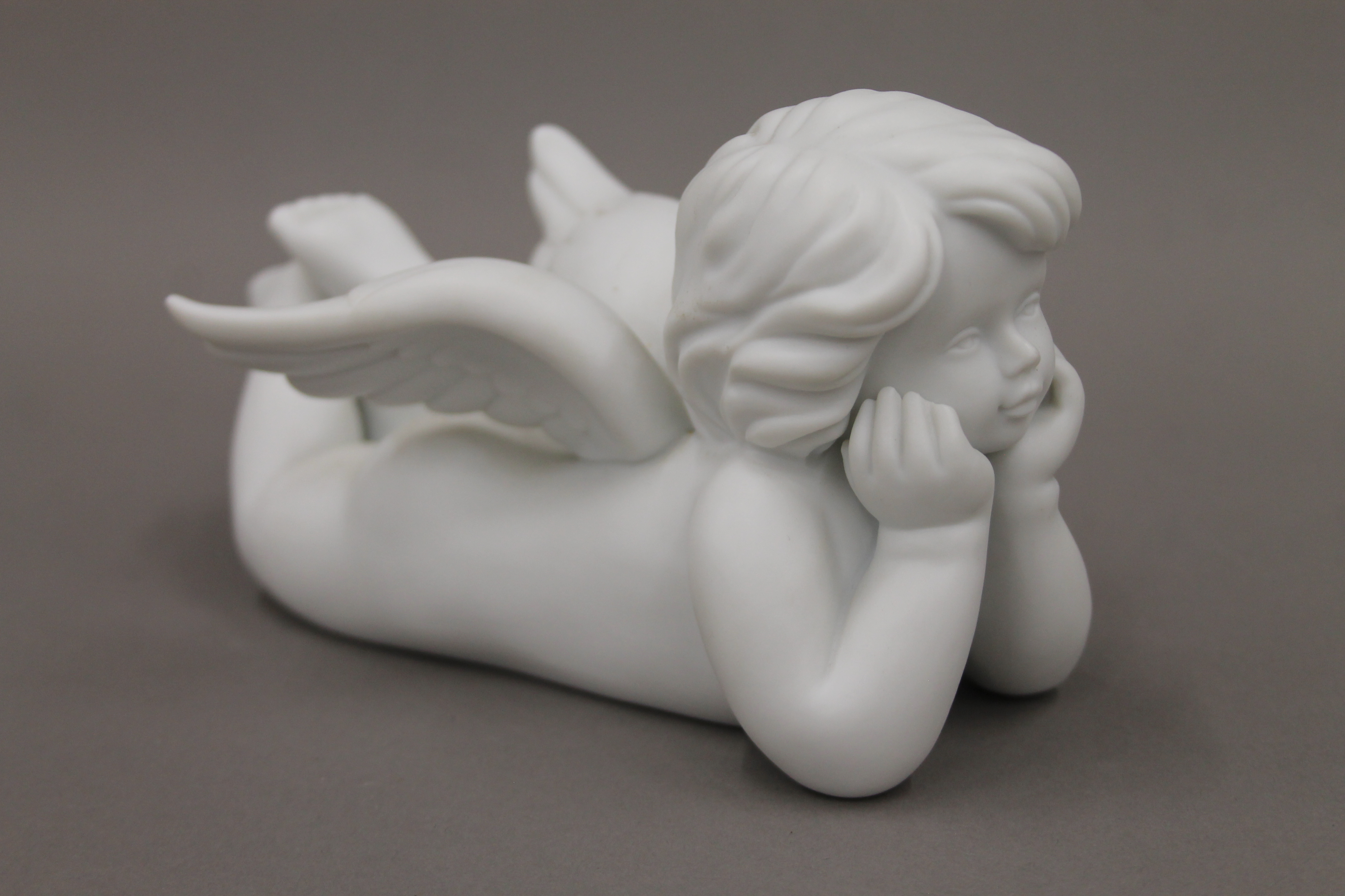 A Rosenthal bisque model of a cherub. 17 cm long.
