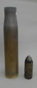 A brass artillery shell case and a shell head. The former 70.5 cm high.