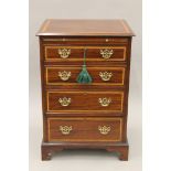 A small Edwardian crossbanded mahogany chest of drawers with brushing slide. 56 cm wide, 81.