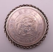 An 1889 Japanese silver One Yen coin brooch. 4.75 cm diameter.