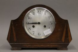 An oak mantle clock. 33 cm wide.