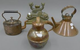 Two copper kettles, a copper jug and a brass doorstop. The largest 21 cm high.