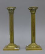 A pair of brass Corinthian column candlesticks. 25 cm high.